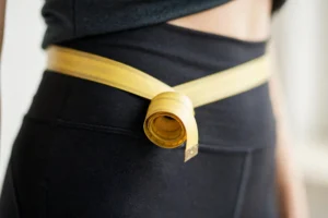 Measuring tape around a waist to calculate body fat percentage with the Navy method